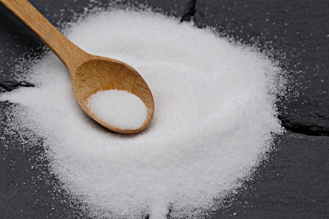 Facts and Myths: Everything You Need to Know about Sea Salt - close-up image of sea salt and wooden spoon.
