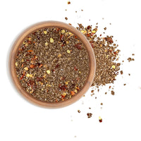 Smoked Red Pepper Sea Salt in a ceramic bowl with scattered seasoning on a white background.